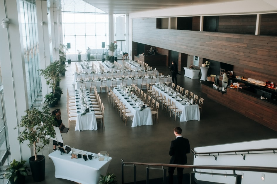 Banquet hall set with long white-linen tables for a corporate dinner