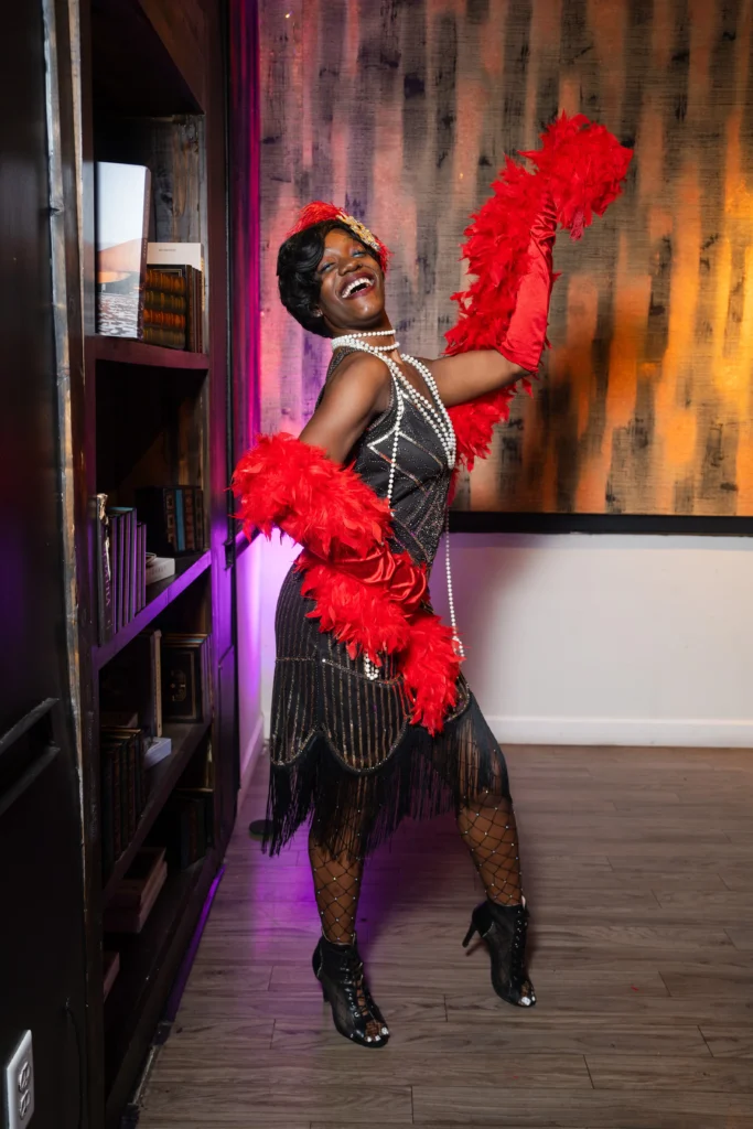 Performer in a red feather boa at a themed party